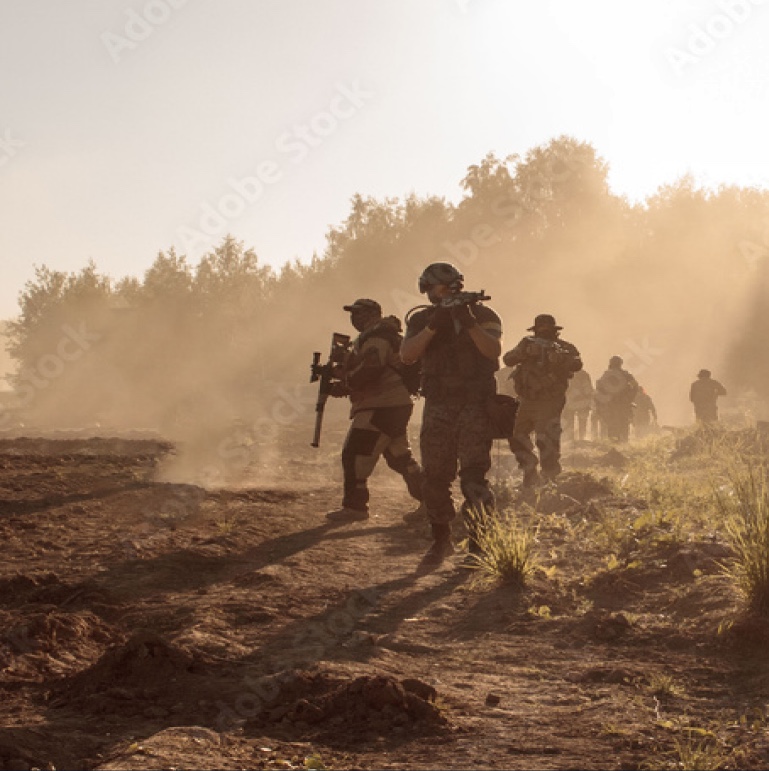 Dismounted team moving through open terrain at dusk