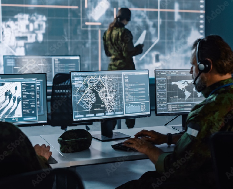 Operators monitoring multiple displays in a command center